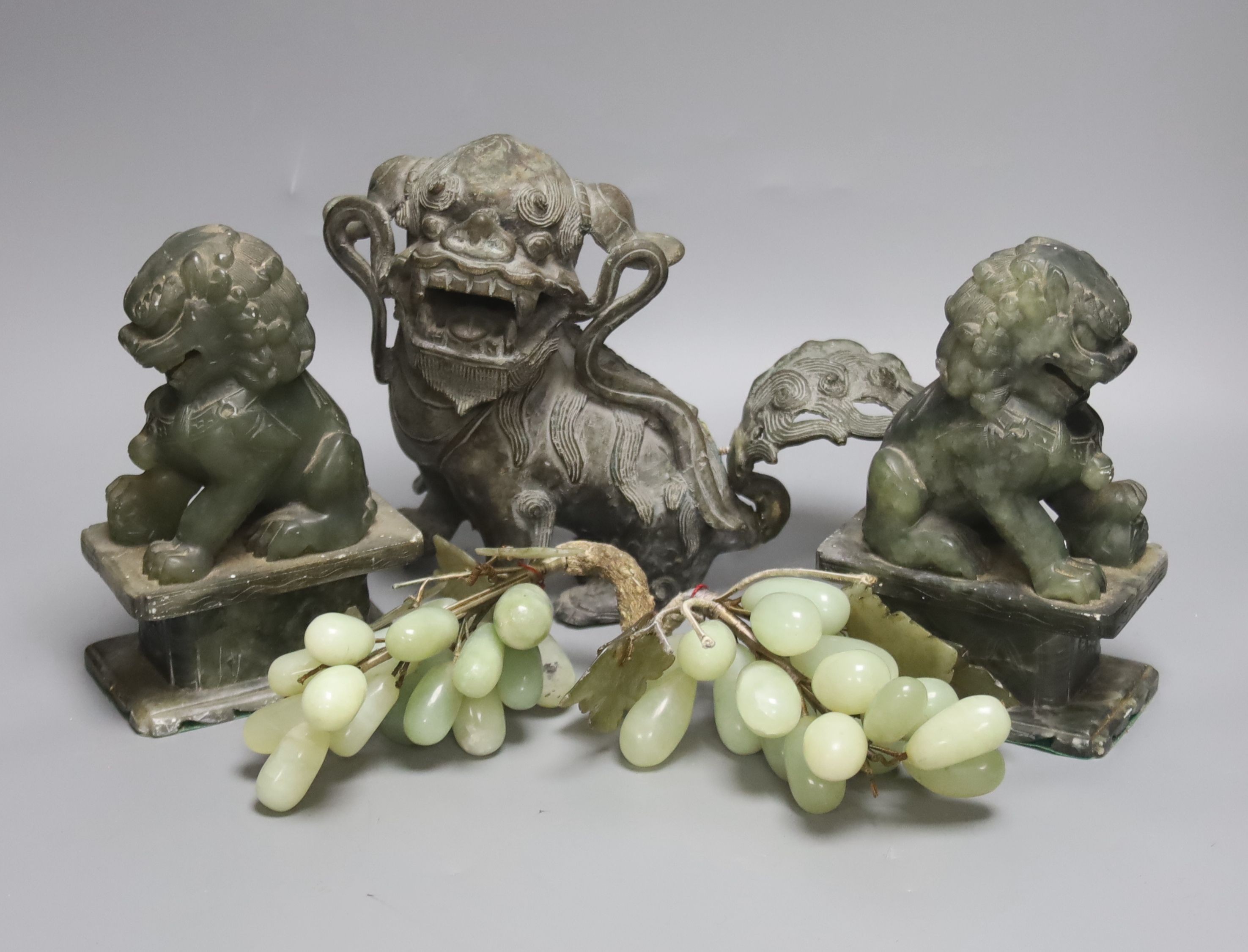 A South East Asian bronze shi-shi dog, 19cm high, a pair of soapstone temple dogs and hardstone grapes